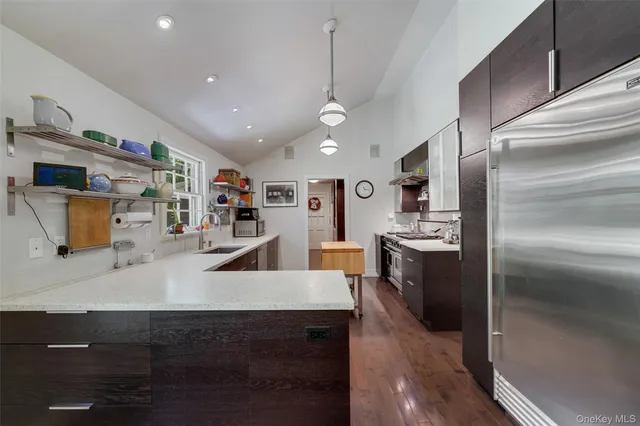 a kitchen with stainless steel appliances granite countertop a sink a stove and a refrigerator