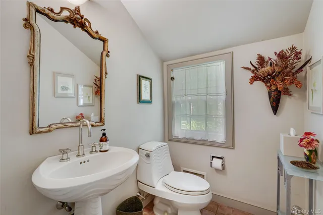 a bathroom with a toilet sink and mirror