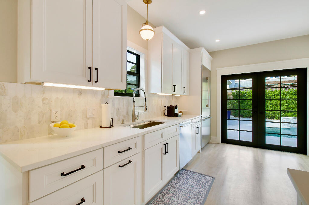 623 Avon Road West Palm Beach, FL 33401 - Photo 13 of 39 a view of a kitchen with a sink and dishwasher with wooden floor