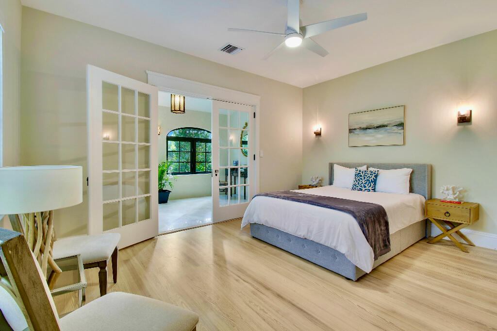 623 Avon Road West Palm Beach, FL 33401 - Photo 17 of 39 a spacious bedroom with a large bed and a chandelier