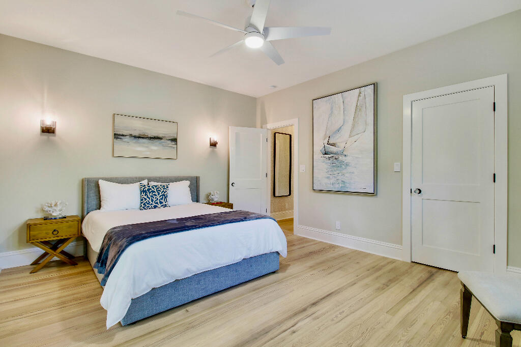 623 Avon Road West Palm Beach, FL 33401 - Photo 18 of 39 a bedroom with a large bed and a chandelier