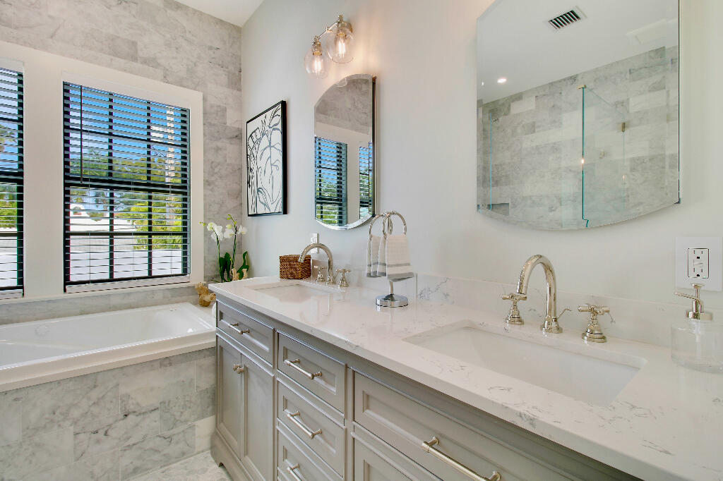 623 Avon Road West Palm Beach, FL 33401 - Photo 25 of 39 a bathroom with double vanity sink a mirror and a bathtub