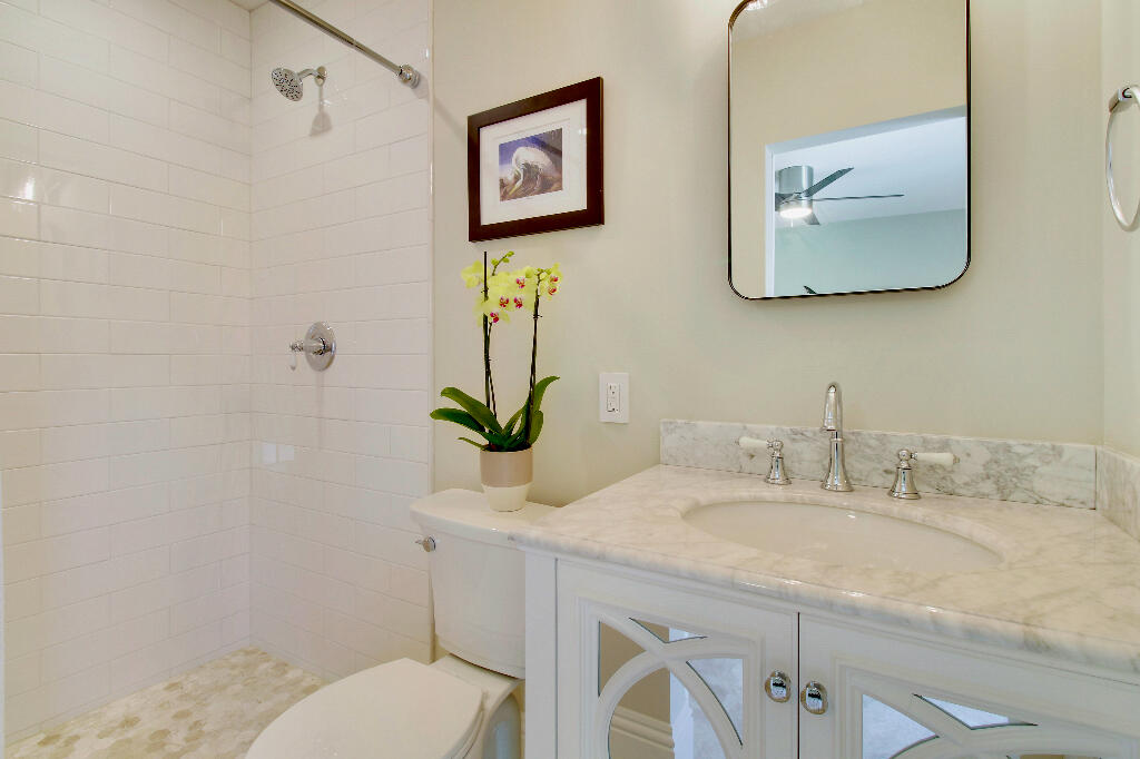 623 Avon Road West Palm Beach, FL 33401 - Photo 34 of 39 a bathroom with a toilet sink and mirror