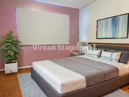 a bedroom with a large bed and a potted plant