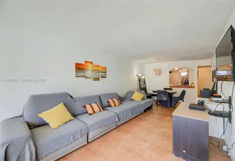 a living room with furniture a couch and two large window