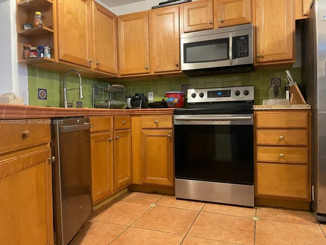 a kitchen with stainless steel appliances granite countertop a stove and a microwave
