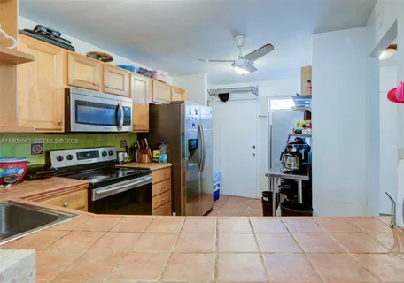 a kitchen with stainless steel appliances kitchen island granite countertop a refrigerator and a stove top oven