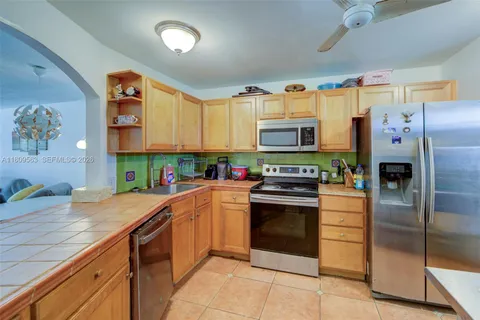 a kitchen with granite countertop a refrigerator and a stove top oven