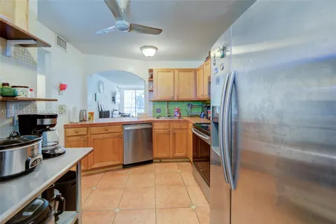 a kitchen with a sink refrigerator and cabinets