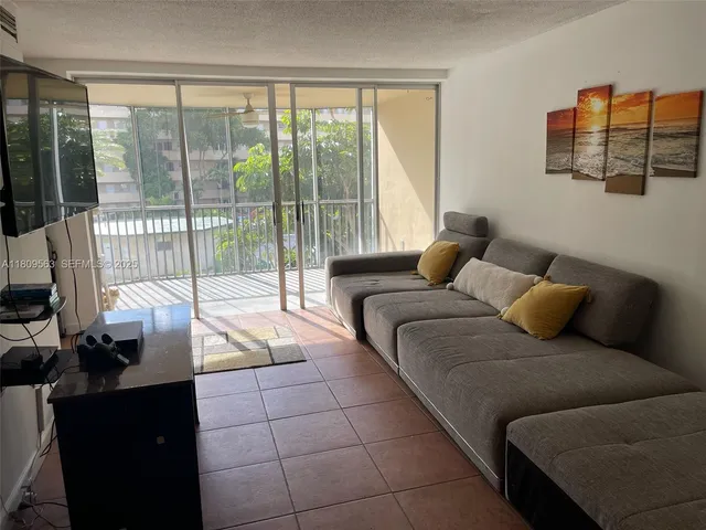 a living room with furniture and a floor to ceiling window
