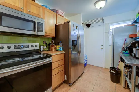 a kitchen with stainless steel appliances granite countertop a refrigerator and a stove