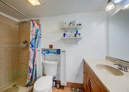 a bathroom with a sink a toilet and shower curtain
