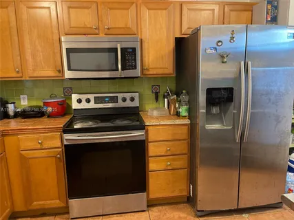a kitchen with stainless steel appliances granite countertop a refrigerator stove and microwave