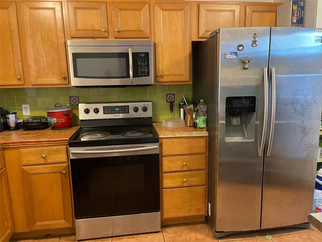 a kitchen with stainless steel appliances granite countertop a refrigerator stove and microwave