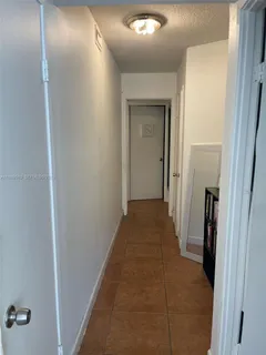 a view of a hallway with a livingroom and a bathroom with sink