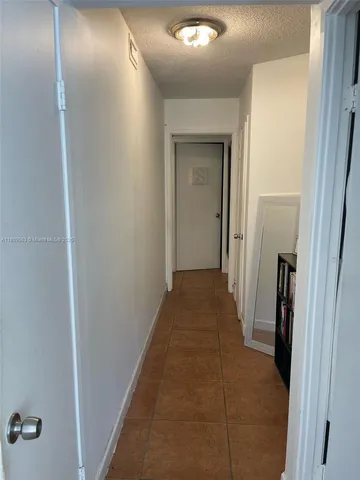 a view of a hallway with a livingroom and a bathroom with sink