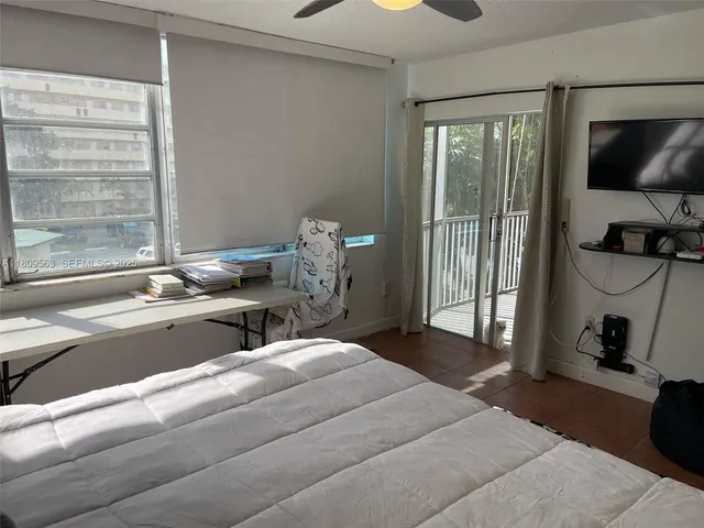 a bedroom with a bed and a flat tv screen on the dresser