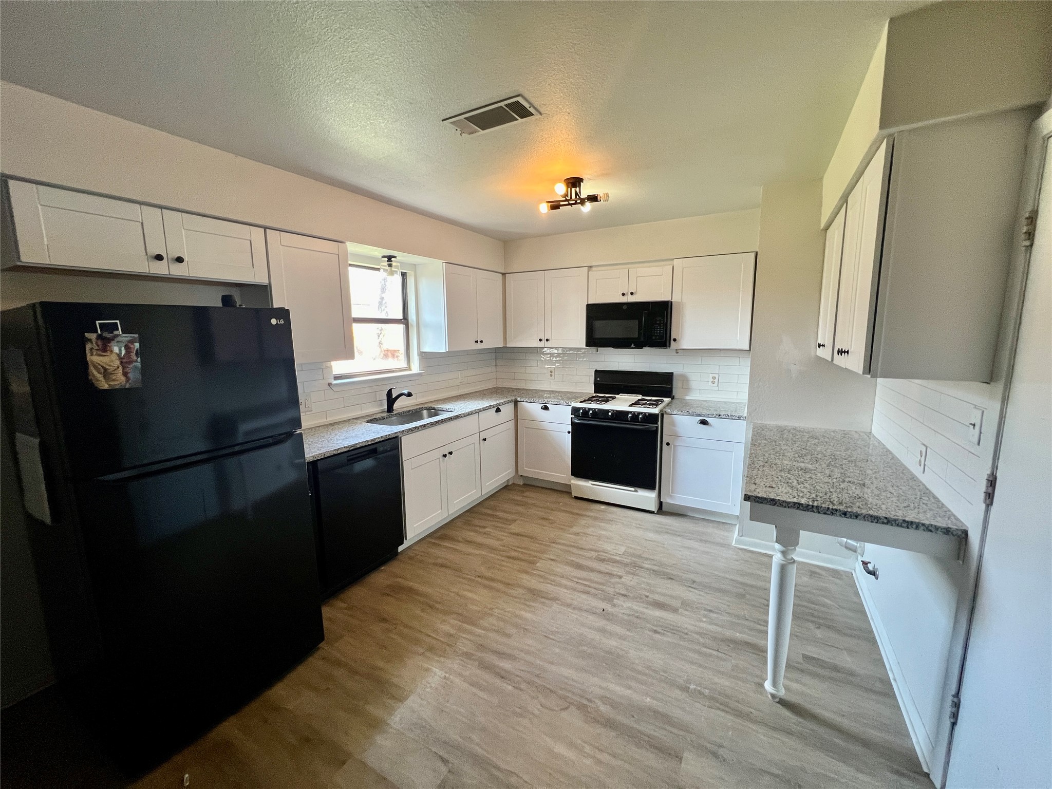 2212 Rifle Bend Drive Georgetown, TX 78626 - Photo 7 of 15 a kitchen with granite countertop a refrigerator stove top oven and sink