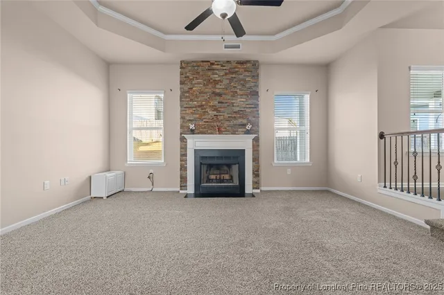an empty room with windows and fireplace
