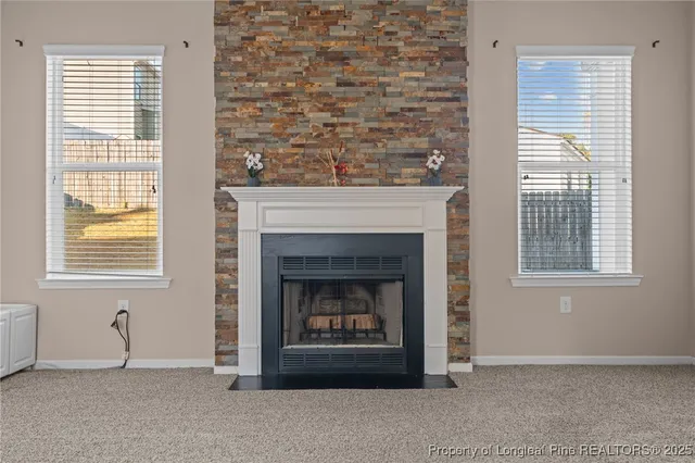 a living room with a fireplace and windows
