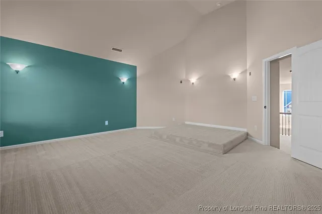 an empty room with windows and ceiling fan