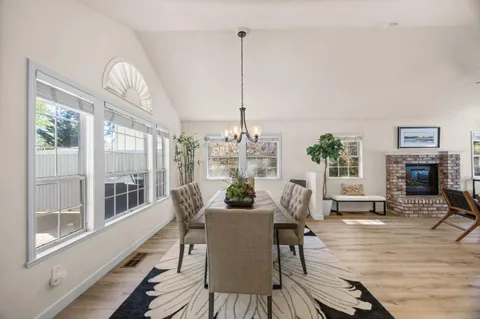 a dining room with furniture a chandelier and wooden floor
