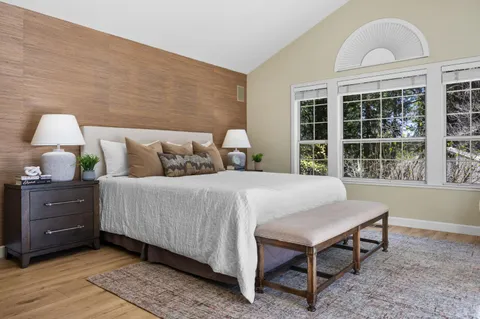a large bed sitting in a bedroom next to a window