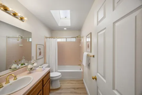 a bathroom with a double vanity sink toilet mirror and shower