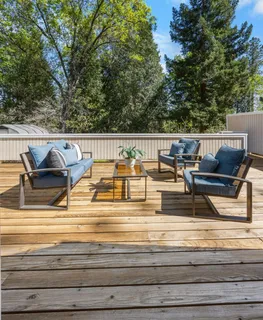 a view of roof deck with furniture and trees
