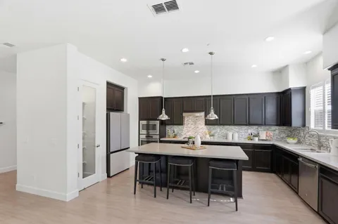 a kitchen with stainless steel appliances kitchen island granite countertop a sink and cabinets