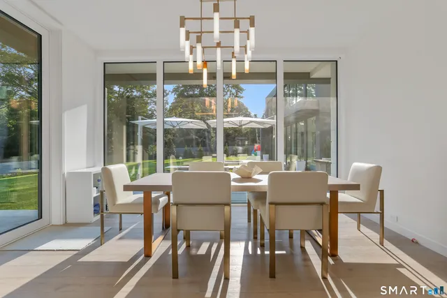 a dining room with furniture a chandelier and wooden floor