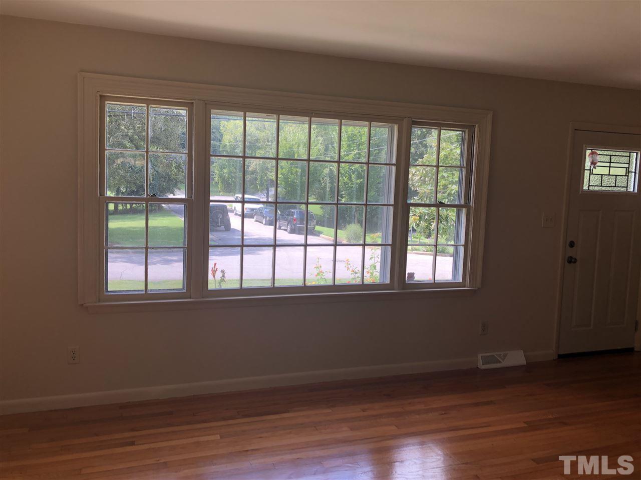 822 Chatham Lane Raleigh, NC 27610 - Photo 3 of 13 a view of an empty room with wooden floor and a window