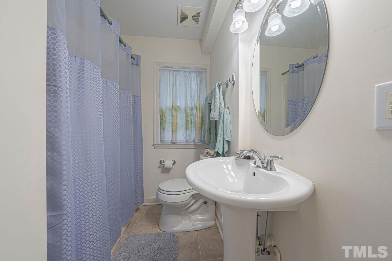 2617 Grant Avenue Raleigh, NC 27608 - Photo 12 of 28 a bathroom with a sink toilet and a mirror