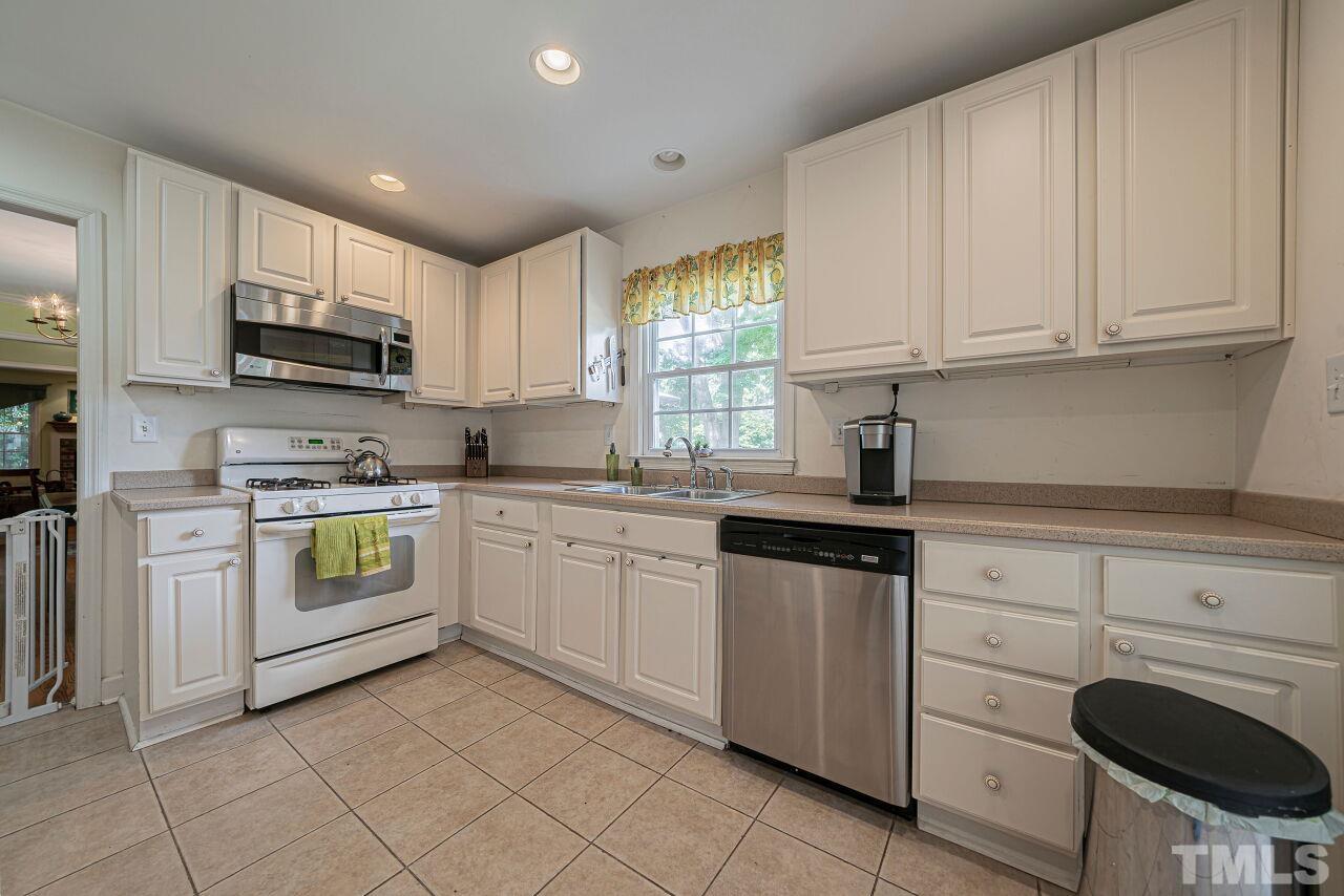 2617 Grant Avenue Raleigh, NC 27608 - Photo 20 of 28 a kitchen with granite countertop white cabinets and white stainless steel appliances