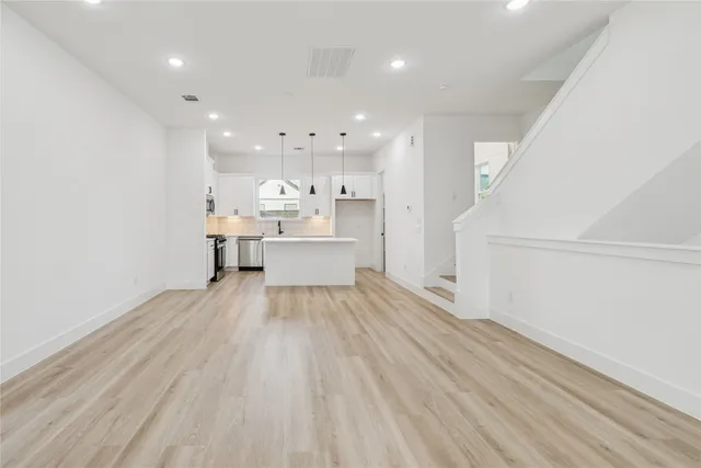 a view of a kitchen with wooden floor and electronic appliances