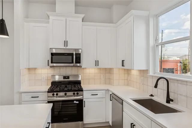 a kitchen with stainless steel appliances a sink a stove and microwave