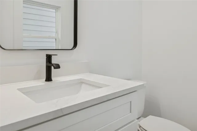 a bathroom with a sink a toilet and vanity