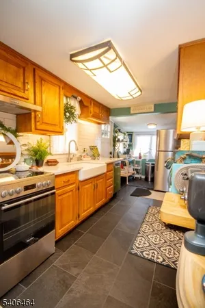 a kitchen with stainless steel appliances kitchen island granite countertop a stove and white cabinets