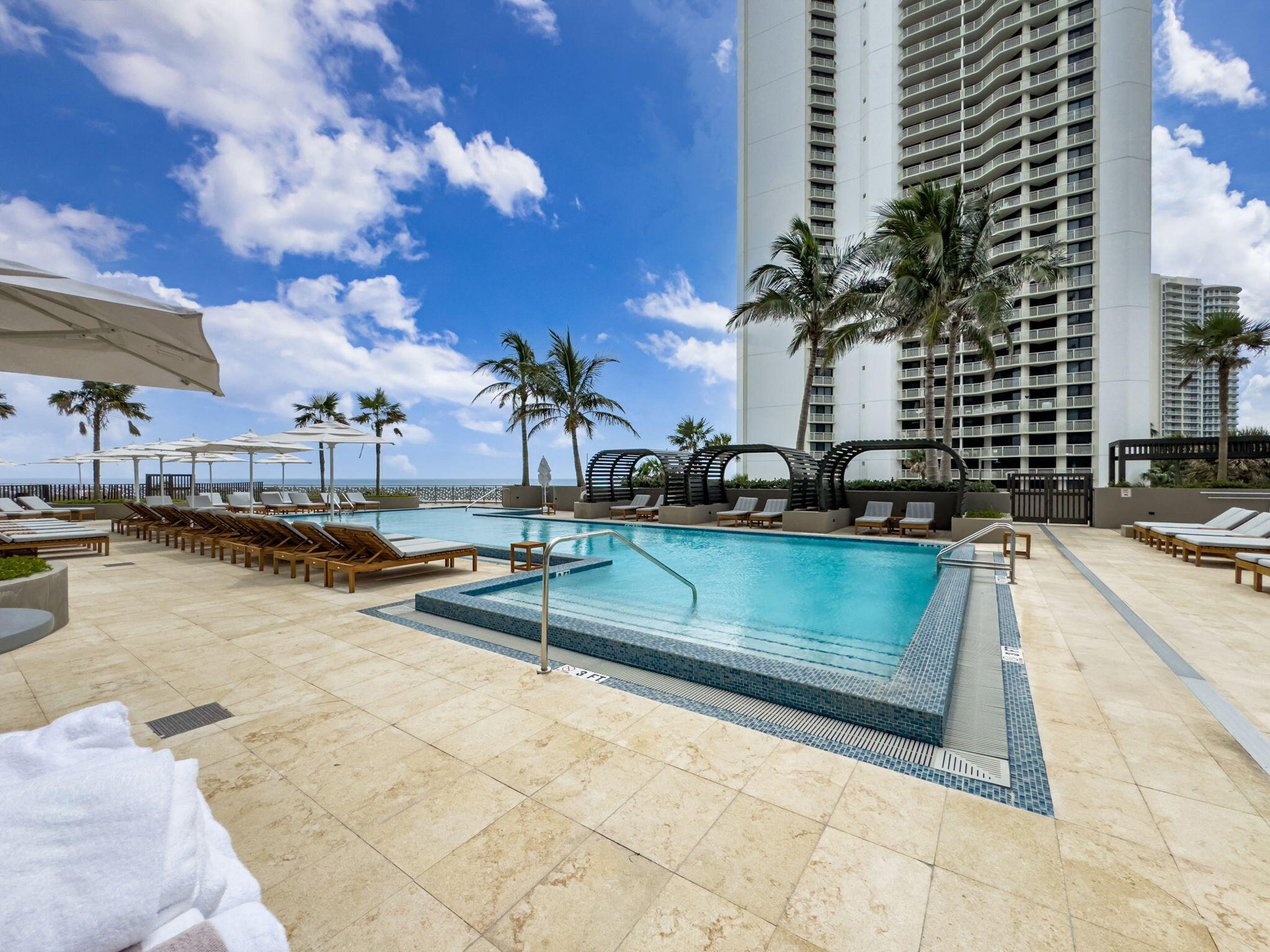 3100 North Ocean Drive, Unit 1210H Singer Island, FL 33404 - Photo 71 of 93 a view of a swimming pool with a lounge chairs
