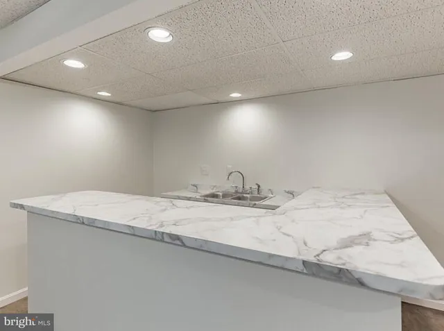 a bathroom with a granite countertop sink and a white cabinets