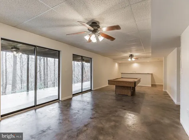 a view of a livingroom with couch wooden floor and a ceiling fan