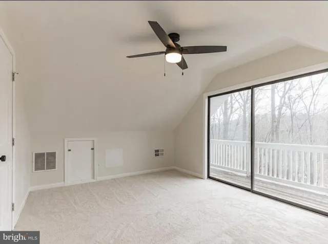 an empty room with a ceiling fan and windows