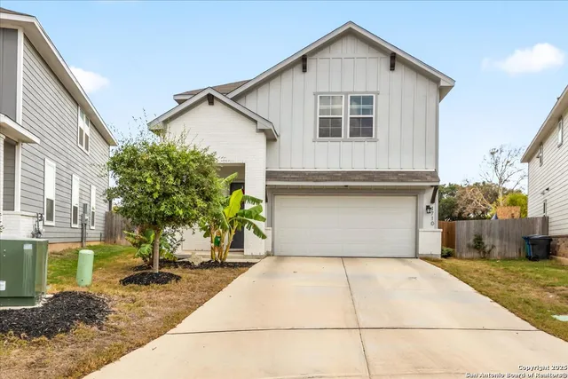 a view of a house with a yard and potted plants