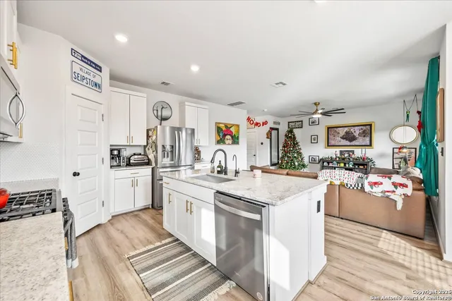 a kitchen with stainless steel appliances kitchen island granite countertop a stove and cabinets