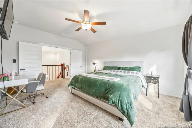 a living room with a bed furniture and a flat screen tv