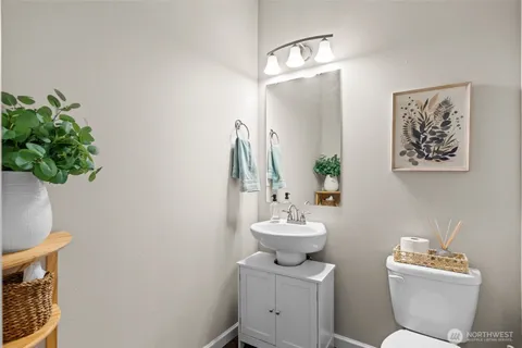 a bathroom with a toilet a sink and mirror
