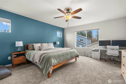 a spacious bedroom with a bed and ceiling fan