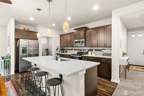 a kitchen with kitchen island wooden cabinets and refrigerator