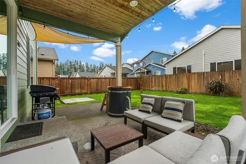 a view of a patio with a table chairs and a yard