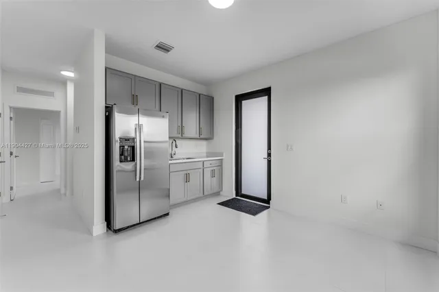 a kitchen with white cabinets and refrigerator